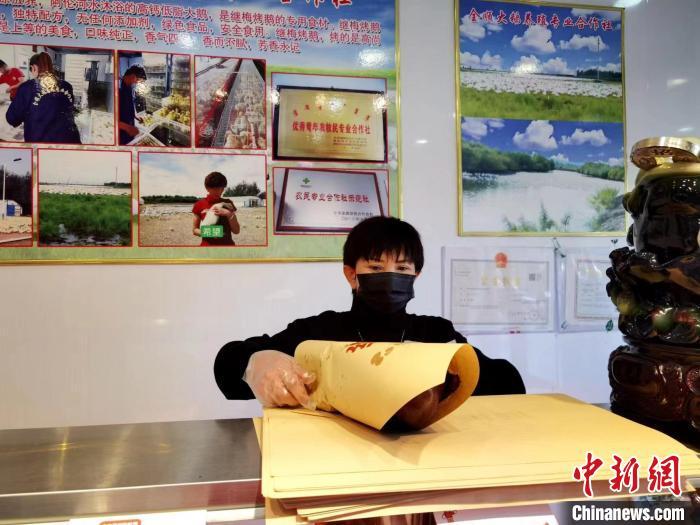 圖為鄭繼梅正在打包烤鵝?！≈x宏秀供圖